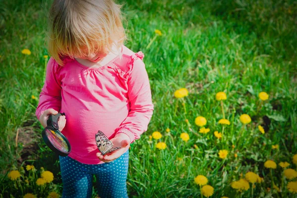 Klein meisje op zoek naar vlinders, kinderen leren de natuur — Stockfoto