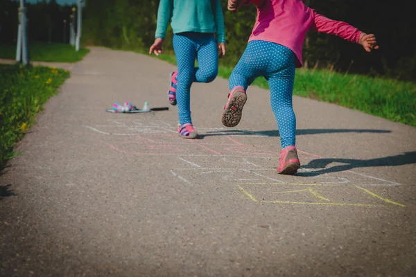 Meninas jogar hopscotch no playground, crianças ao ar livre — Fotografia de Stock