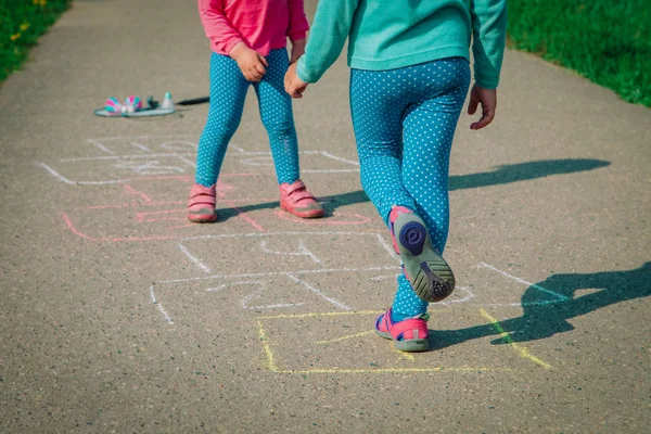 Gadis kecil bermain hopscotch di taman bermain, anak-anak di luar ruangan — Stok Foto