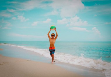 mutlu genç çocuk plajda top oynamak