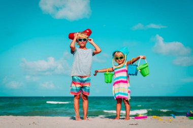 mutlu kız ve erkek kumsalda oyuncaklarla oynamak