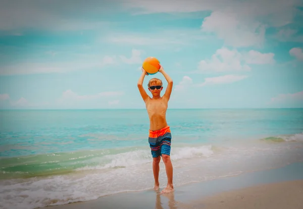 Szczęśliwy młody chłopak grać piłkę na plaży — Zdjęcie stockowe