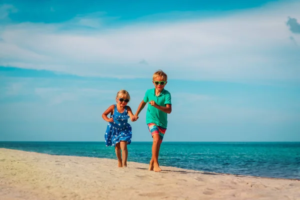 Happy kids-jongen en meisje draait op strand — Stockfoto