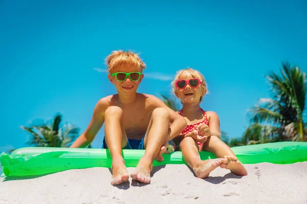 Счастливые мальчик и девочка веселятся на пляже — стоковое фото