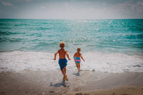Felice ragazzo e ragazza correre nuotare sulla spiaggia — Foto Stock