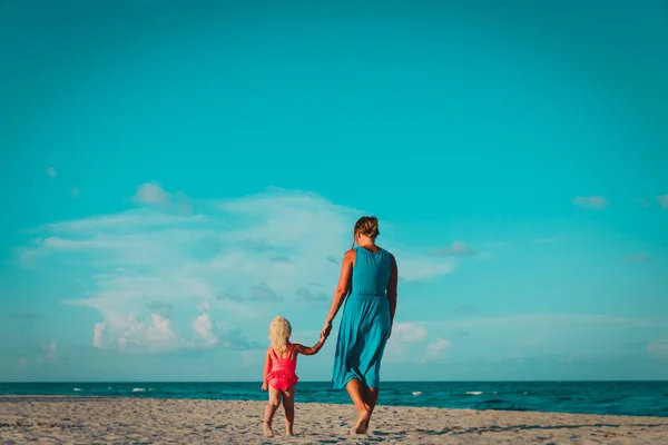 Moeder met kleine dochter lopen op het strand, ouderschap — Stockfoto