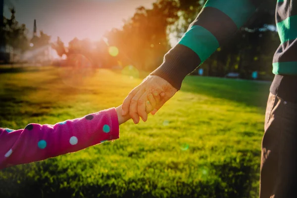 Padre e figlia che si tengono per mano al tramonto, genitorialità — Foto Stock