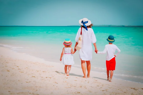 Madre y dos niños caminando en la playa — Foto de Stock