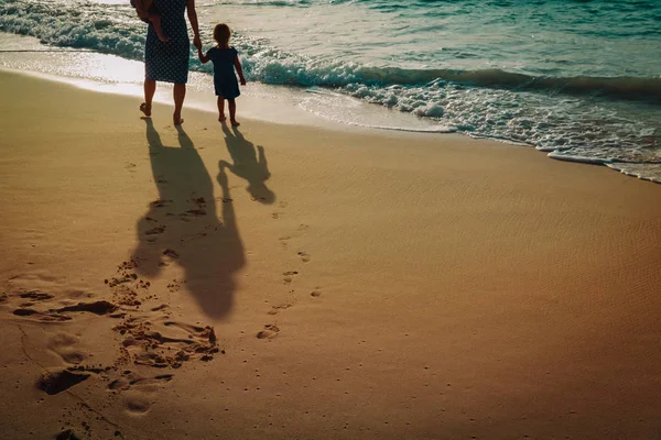 Mãe e crianças andando na praia deixando pegada na areia — Fotografia de Stock