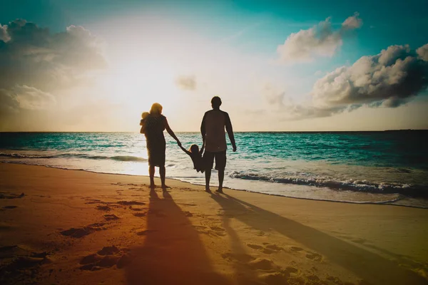 Famille heureuse avec les enfants jouent à la plage du coucher du soleil — Photo