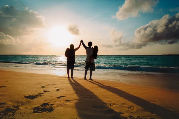 Lycklig familj med barn spela på sunset beach — Stockfoto