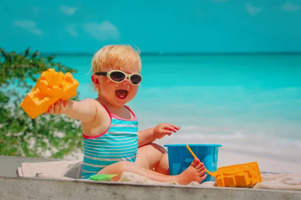 Roztomilá malá holčička hrát s hračkami na pláži — Stock fotografie