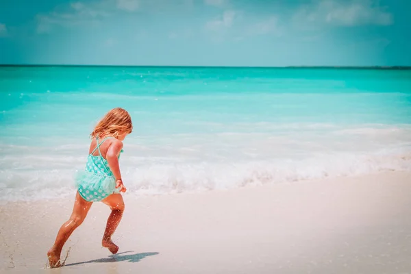 Feliz niña ejecutar jugar con olas en la playa —  Fotos de Stock