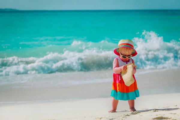 Милая маленькая девочка с сумкой на тропическом пляже отдыха — стоковое фото