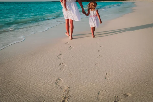 Mutter und Kinder gehen am Strand spazieren und hinterlassen Fußabdrücke im Sand — Stockfoto