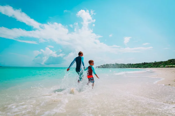 Otec a syn hrát s vody na pláži — Stock fotografie