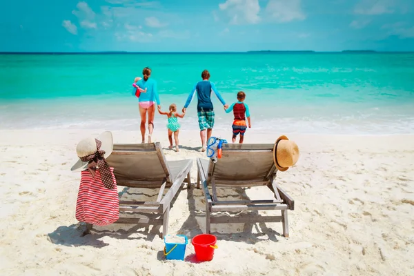 Plajda tatil olan çocuklar ile sandalye ve mutlu aile — Stok fotoğraf