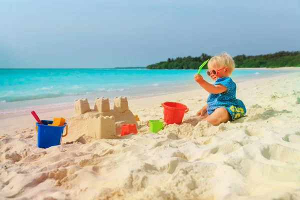 Menina bonito brincando com areia na praia — Fotografia de Stock