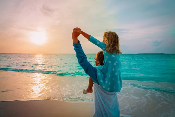Pai e filha brincam na praia do pôr do sol — Fotografia de Stock