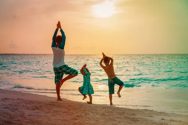 Vader met kinderen sporten bij Sunset Beach, familie doen yoga — Stockfoto