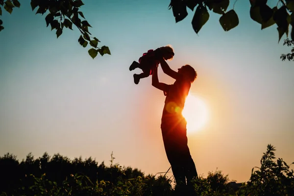 父亲和小女儿的轮廓在日落时播放 — 图库照片