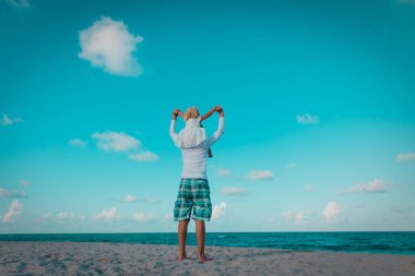 Baba ve küçük kız sahilde oynuyorlar.