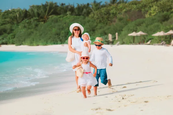 Gelukkig gezin met kinderen zich vermaken op tropisch strand — Stockfoto