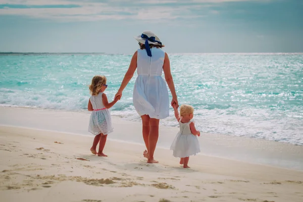 Matka s malými dcerami chodit na písečné pláži — Stock fotografie