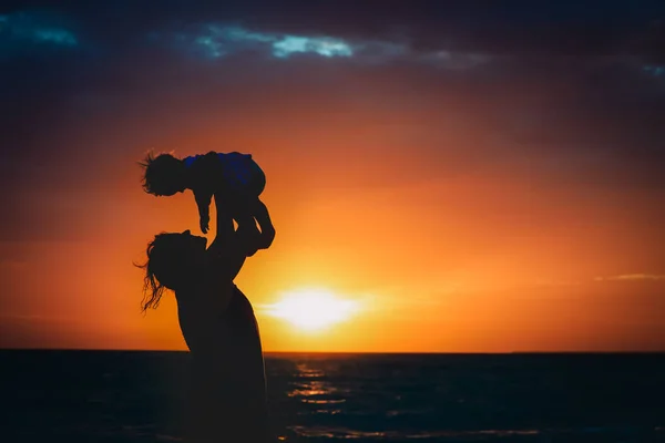 Moeder en kleine dochter spelen bij zonsondergang — Stockfoto