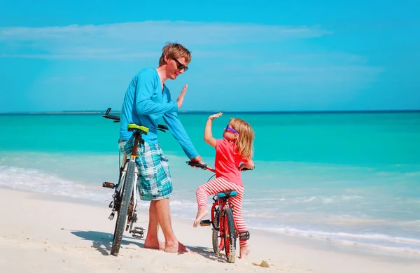 Père avec petite fille faisant du vélo sur la plage — Photo