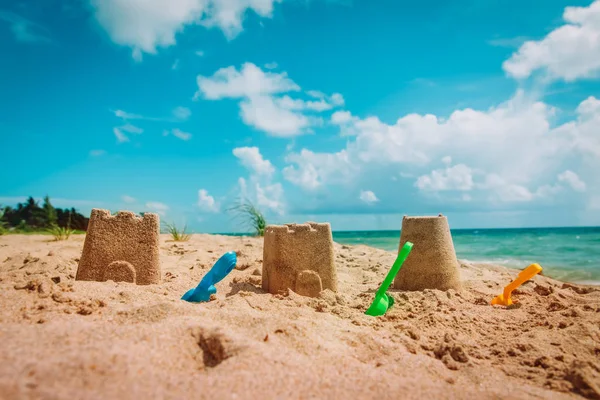 Castillo de arena y juguetes en vacaciones de playa tropical —  Fotos de Stock
