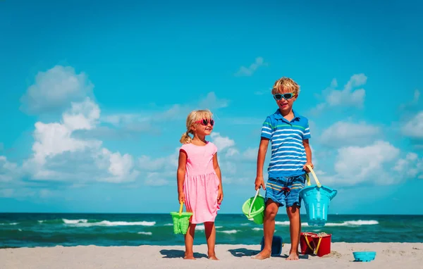 Bambini carino ragazzo e ragazza- giocare con la sabbia sulla spiaggia — Foto Stock