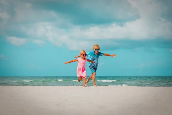 Felice carino ragazzo e ragazza eseguire giocare in spiaggia — Foto Stock