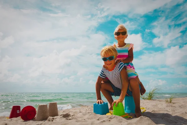 Chica feliz y niño jugar y disfrutar de vacaciones en la playa — Foto de Stock