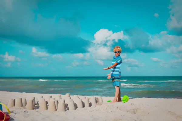 Giovane ragazzo giocare con la sabbia in spiaggia — Foto Stock