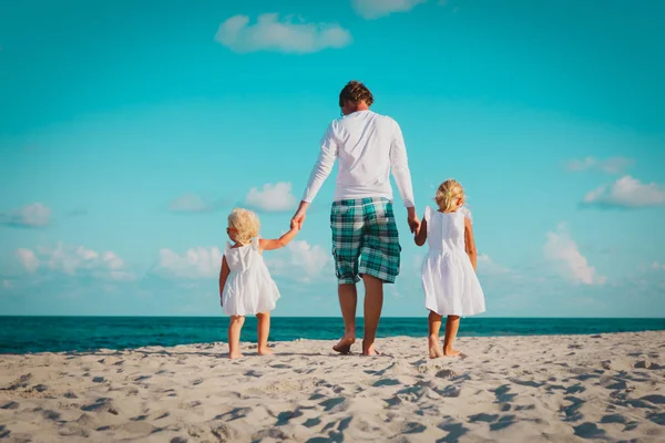 Otec se dvěma dcerky pěšky na pláži — Stock fotografie