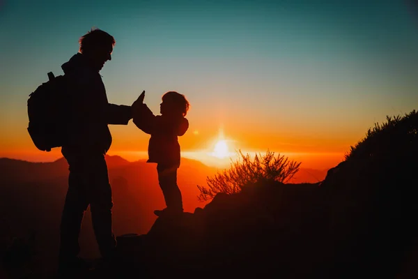 Отец и маленькая дочь путешествуют в горах на закате — стоковое фото