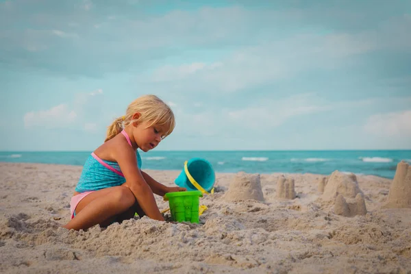 Mignonne petite fille jouer avec le sable sur la plage — Photo