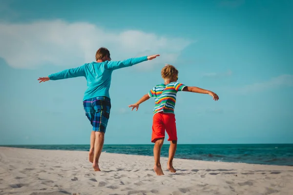 Padre e figlio giocano sulla spiaggia, la famiglia gode di una vacanza al mare — Foto Stock