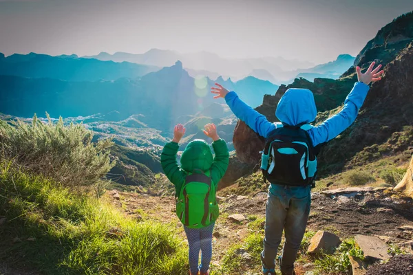 Menino e menina felizes caminhadas nas montanhas do pôr do sol — Fotografia de Stock