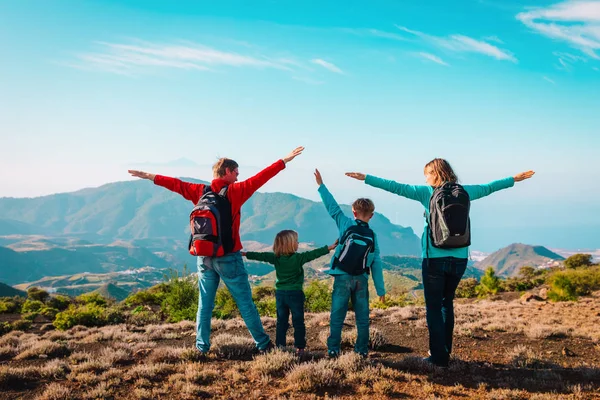 happy mom and dad with kids travel in mountains