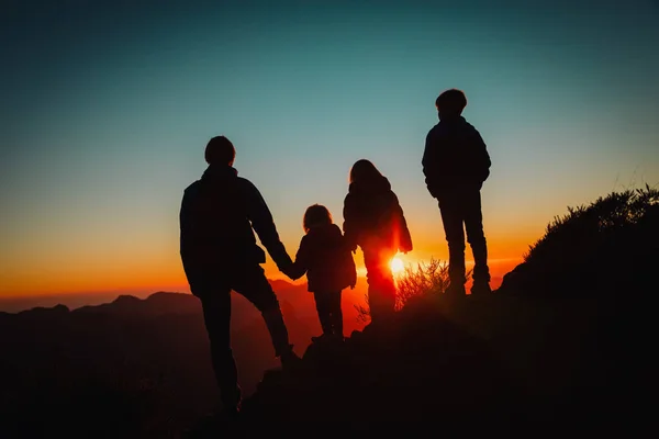 Счастливый отец с детьми путешествуют в горах заката — стоковое фото