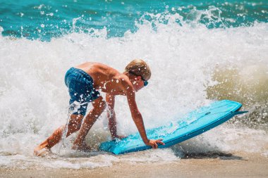 mutlu çocuk denizde sörf keyfini, çocuklar vacaton su ile oynamak