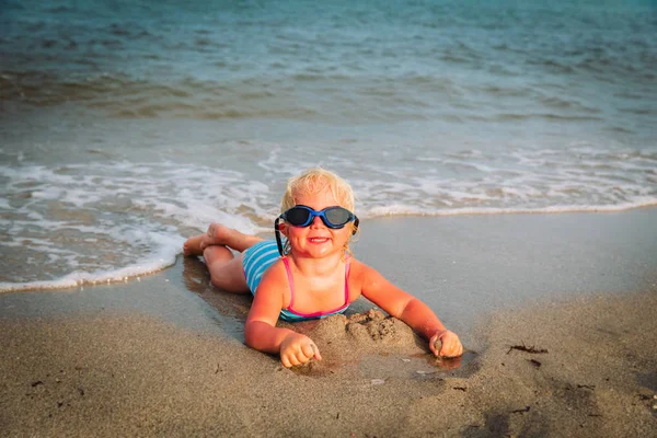 Mignonne petite fille apprendre à nager sur la plage — Photo