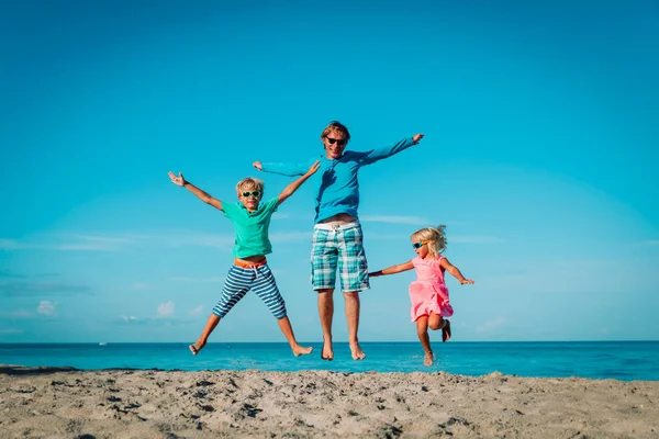Šťastný otec s dětma-chlapeček a dívčí hráčkou na pláži — Stock fotografie