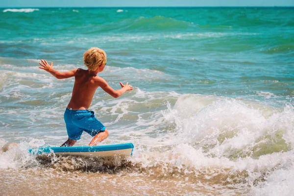 Happy boy enjoy surfing at sea, kids play with water on vacaton — Stock Photo, Image