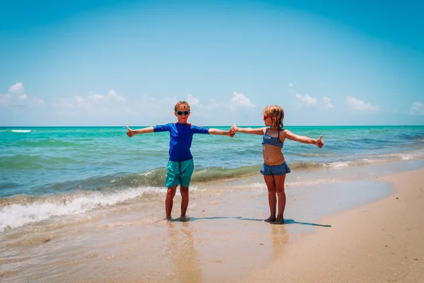 Šťastná dívka a chlapec hrají a baví se na plážových prázdninách — Stock fotografie