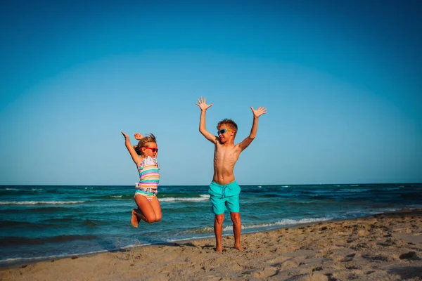 Menino e menina feliz jogar na praia — Fotografia de Stock