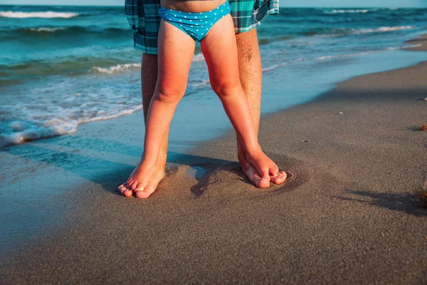 Padre e hija pequeña pies en la playa, concepto de crianza — Foto de Stock