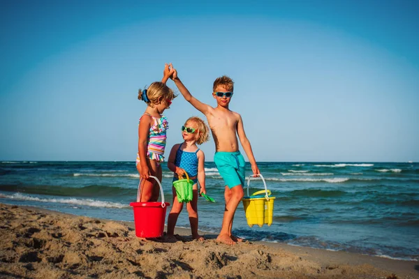 Niños felices juegan en la playa, niño y niñas se divierten en el mar —  Fotos de Stock